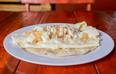 Plate of delicious Quesillo with pickled onion served on the table, Traditional quesillo plate with...