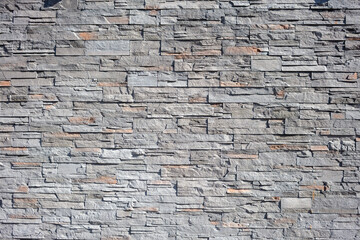 Empty slate stone wall background texture. Granite masonry, mosaic construction. Copy space