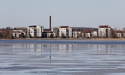 Fototapeta na wymiar Apartment houses on a shore of a lake in spring