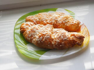 croissant on a plate on the table next to the window