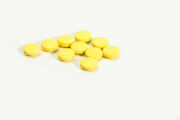 Close up shots of medicine tablets and capsules on white background. White and colored tablets placed in a group.