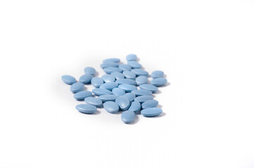 Close up shots of medicine tablets and capsules on white background. White and colored tablets placed in a group.