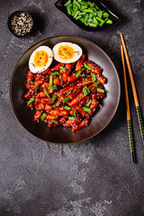 Tteokbokki, Teopokki fried rice cake in black bowl.