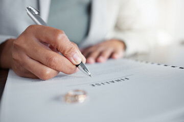 Signature, ring and divorce paper of a woman at table with legal paperwork, anxiety or documents....