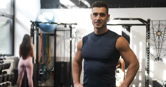 Content strong man standing in gym