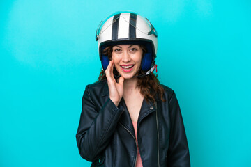 Young caucasian woman with a motorcycle helmet isolated on blue background with surprise and shocked facial expression