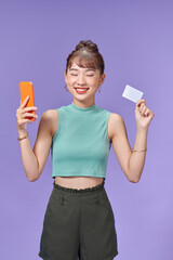 smiling girl holding a credit card and mobile phone online shopping