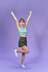 Full length portrait of an excited young woman jumping and celebrating