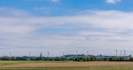 Meadow with many wind turbines under a cloudy sky