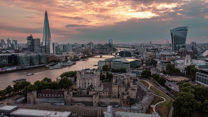 Fototapeta premium Aerial shot of the tower of London with boats on river Thames at sunset