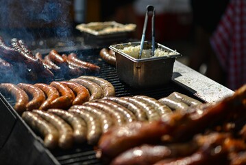 a group of sausages cooking on the grill on top of a grill pan