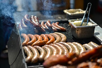 an outdoor grill filled with lots of sausage and other foods