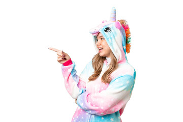 Young girl with unicorn pajamas over isolated chroma key background pointing finger to the side and presenting a product © luismolinero