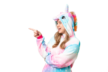 Young girl with unicorn pajamas over isolated chroma key background pointing finger to the side and presenting a product