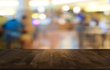 Empty dark wooden table in front of abstract blurred bokeh background of restaurant . can be used for display or montage your products.Mock up for space.