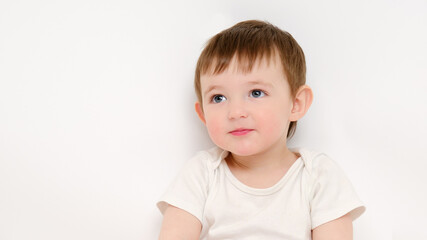 Naklejka premium Cute baby on a studio white background. Portrait of a smiling pretty child. Kid aged about two years (one year nine months)