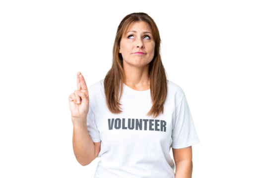 Middle age volunteer woman over isolated background with fingers crossing and wishing the best