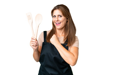 Middle age caucasian woman holding a rolling pin over isolated background celebrating a victory