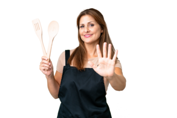 Middle age caucasian woman holding a rolling pin over isolated background counting five with fingers