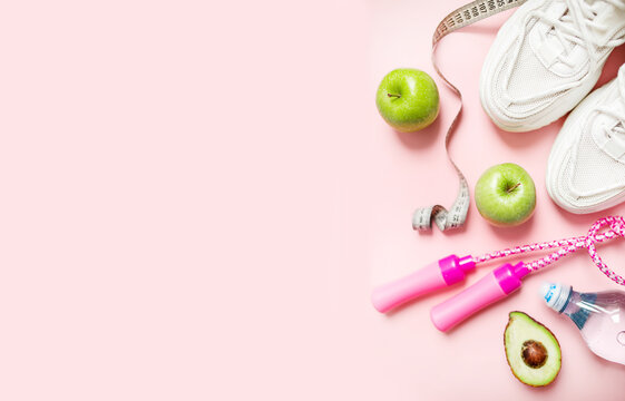 stylish layout. healthy lifestyle and weight loss concept. fresh green apples, a bottle of water, a measuring tape, sneakers and a skipping rope on a pink pastel background. flat lay.  - Powered by Adobe