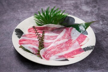 Close-up shot of raw bacon slices on a plate