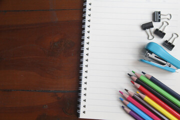 lots of colored pencils and a notepad on the table