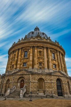 Vertical shot of Radcliffe Camera library on blue cloudy sky background in Oxford, England