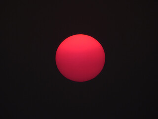 red sun of sunset on black sky background