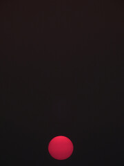 red sun of sunset on black sky background