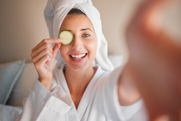Woman, spa and selfie with cucumber on eye in comic portrait for wellness, self care and relax. Girl, fruit and face for skincare, health and smile for cosmetics, beauty and natural glow in morning