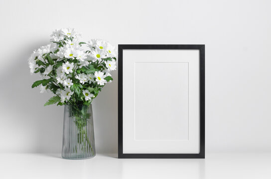 Black portrait artwork frame mockup with white flowers bouquet