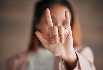 Hand, sign language and love with a person closeup in studio on a blurred background for communication. Emoji, icon or affection and an adult indoor to gesture romance with a fingers icon signal