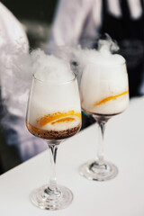 Spritz Aperol cocktail with orange slice and ice cubes on white table.