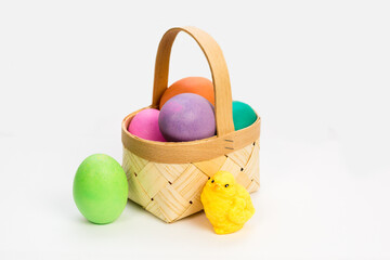 A small wicker basket made veneer with colored Easter eggs made of handmade soap.