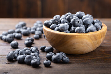 Fresh blueberry in wooden bowl. Concept of healthy and dieting eating.