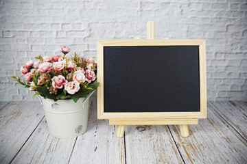 Empty chalk board and alarm clock on wooden background