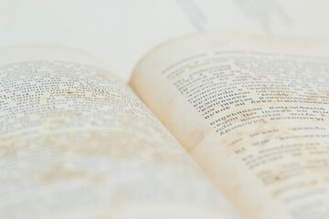 Fototapeta premium Open old book with text on white background. The concept of reading literature, education and book publishing. Free space for text