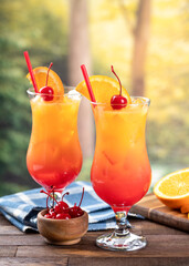Tequila sunrise cocktail with orange slice and cherry