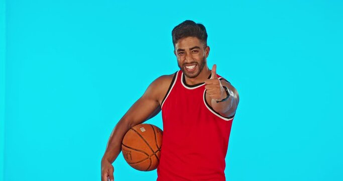 Basketball, man and thumbs up for success in sports isolated in studio on blue background mockup. Face portrait, happy person or ball spin with emoji for exercise goals, like or hand gesture for yes.