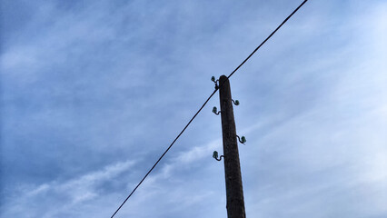 Power electric pole with line wire on blue background close up, photography consisting of power electric pole with line wire under sky, line wire in power electric pole for residential buildings