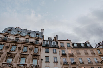 Exterior of aged residential building of beige color with glass windows and beautiful cast iron...