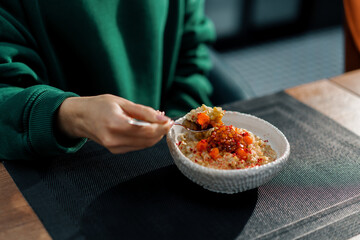 girl in a restaurant eating freshly made oatmeal with caramelized fruit for breakfast close-up