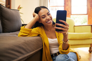 Smile, relax and a woman with a phone for an app, communication and social media. Happy, funny and a girl reading a text message, chat or notification on a mobile in the living room of a house - Powered by Adobe