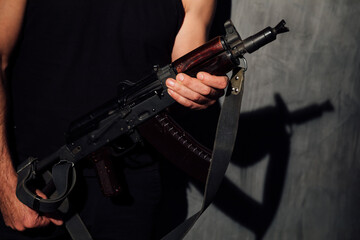 a man holds a military assault rifle in his hands