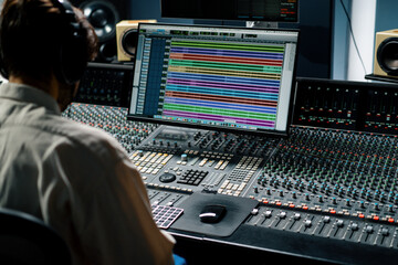 Sound engineer working in music studio with monitors and equalizer on screen mixing and mastering...