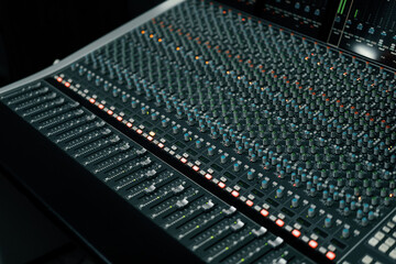 A recording studio control panel mixer with an equalizer faders buttons for broadcasting a...