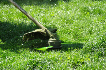 Close-up of public utilities mow the grass in the park.