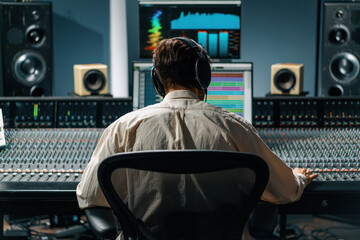 Sound engineer working in music studio with monitors and equalizer on screen mixing and mastering...