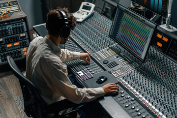 Sound engineer working in music studio with monitors and equalizer on screen mixing and mastering...