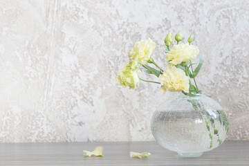 yellow eustoma in  glass vase on table